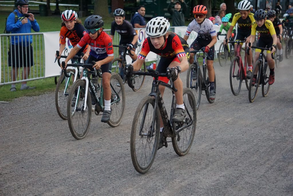 Photograph of a group of bikers racing across gravel